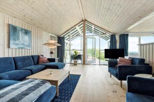 a living room with blue couches and a tv at 8903-Allingabro-Fyrrevej-12 in Allingåbro