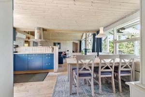 a kitchen and dining room with a table and chairs at 8903-Allingabro-Fyrrevej-12 in Allingåbro