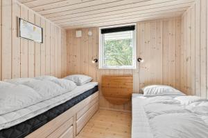 two beds in a small room with a window at 8995-Orsted-Alsikevej-9 in Ørsted