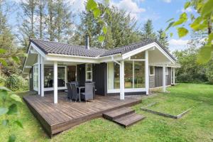 a house with a wooden deck in the yard at 8995-Orsted-Alsikevej-9 in Ørsted
