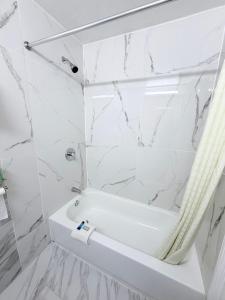 a white bath tub in a bathroom with marble walls at Economy Inn in Longview
