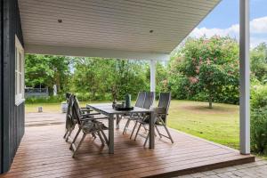 a patio with a table and chairs on a deck at 8920-Orsted-Ternevej-16 in Ørsted