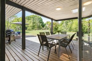 a wooden deck with a table and chairs on it at 8915-Glesborg-Zachosvej-5 in Glesborg