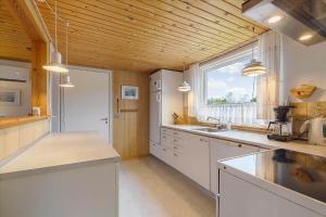 a kitchen with white cabinets and a large window at 8503-Grenaa-Ellevej-29 in Grenå +16 photos