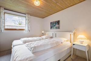 a bedroom with a large white bed with a window at 8503-Grenaa-Ellevej-29 in Grenå
