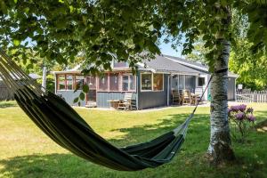 a hammock hanging from a tree in front of a house at 8503-Grenaa-Ellevej-29 in Grenå
