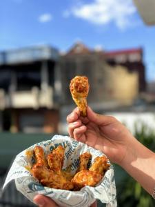 a person holding a piece of food in their hand at Napoli Centro in Santa Ana