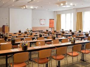 an empty room with tables and chairs in a classroom at Sunday Saarbruecken Sued Standard Room in Saarbrücken +31 photos