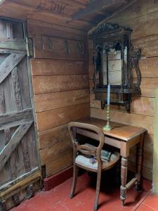 a room with a table with a candle and a chair at Riverside Cabin in Akaroa in Akaroa