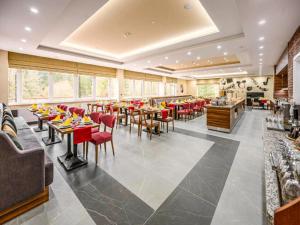 a dining room with tables and red chairs at Sunday Schwarzbachtal Double Room Forest View in Erlbach