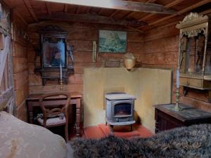 a room with a fireplace and a stove in it at Riverside Cabin in Akaroa in Akaroa