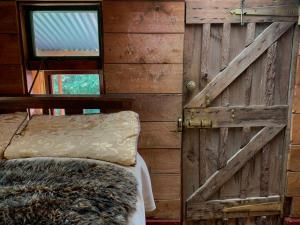a door in a room with a bed and a window at Riverside Cabin in Akaroa in Akaroa +17 photos