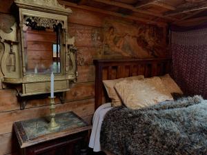 a bedroom with a bed and a mirror on the wall at Riverside Cabin in Akaroa in Akaroa
