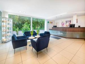 a lobby with chairs and a table in a hospital at Sunday Hotel Bielefeld Standard King Room in Bielefeld