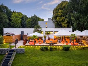 an outdoor patio with orange chairs and umbrellas at Sunday Hotel Bielefeld Standard King Room in Bielefeld
