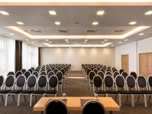 an empty room with rows of chairs in it at Sunday Hotel Bielefeld Standard King Room in Bielefeld