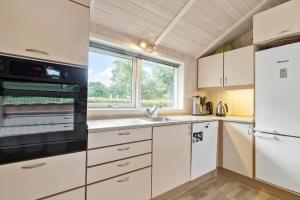 a kitchen with white cabinets and a sink and a window at 8519-Grenaa-Nobilisvej-13 in Grenå +20 photos