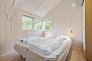 a large white bed in a room with two windows at 8519-Grenaa-Nobilisvej-13 in Grenå