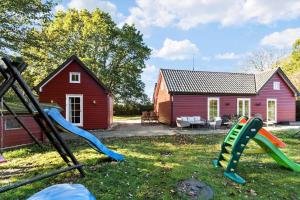 a playground with a red house and some slides at 8514-Grenaa-Sortebaervej-16 in Grenå