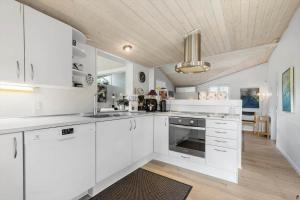a white kitchen with white cabinets and a ceiling at 8908-Allingabro-Poppelvej-7 in Allingåbro +20 photos