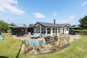 a house with a patio and a garden with plants at 8908-Allingabro-Poppelvej-7 in Allingåbro