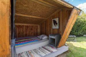 a bed in a wooden shack with a tv in it at 8908-Allingabro-Poppelvej-7 in Allingåbro