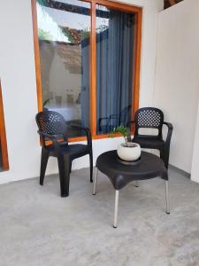 three black chairs and a table with a plant on it at Villa Carlos Tangalle in Tangalle +3 photos
