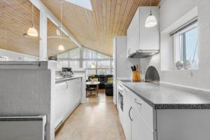 a large kitchen with white appliances and a table at 8848-Glesborg-Floden-4 in Glesborg +19 photos