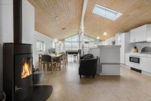 a kitchen and dining room with a fireplace in a house at 8848-Glesborg-Floden-4 in Glesborg