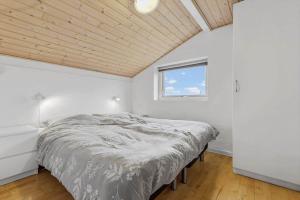 a white bedroom with a bed and a window at 8848-Glesborg-Floden-4 in Glesborg