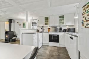 a kitchen with white cabinets and a stove at 8963-Orsted-Spovevej-6 in Ørsted