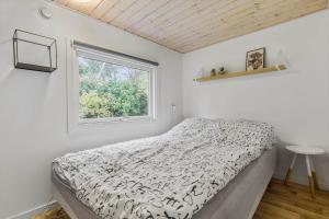 a bedroom with a bed and a window at 8963-Orsted-Spovevej-6 in Ørsted