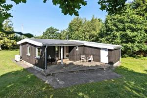 a small cabin with a deck in a field at 8963-Orsted-Spovevej-6 in Ørsted