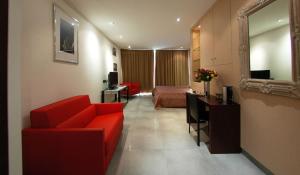 ein Hotelzimmer mit einem roten Sofa und einem Bett in der Unterkunft Cassis Loc - Chambre Meublée in Cassis