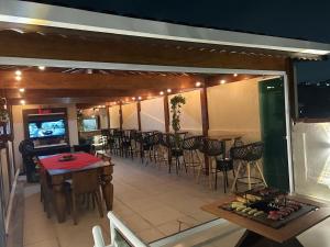 a restaurant with tables and chairs and a television at jacuzzi e eventos em são miguel paulista in São Paulo