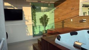 a bathroom with a tub and a tv and a plant at jacuzzi e eventos em são miguel paulista in São Paulo +27 photos