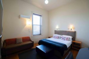 a small bedroom with a bed and a couch at Park Hotel in Mount Gambier