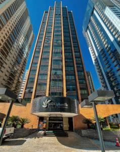a tall building with a sign in front of it at Sol Alphaville Hotel & Residence 1004 in Barueri