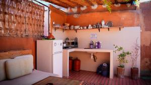 a small kitchen with a refrigerator and a table at Medina Oasis Hostel in Marrakesh