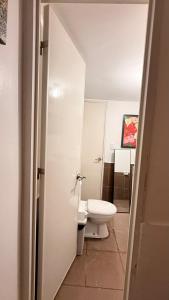 a white bathroom with a toilet and a sink at Casa Alexa - Island Escape in Puerto Princesa City