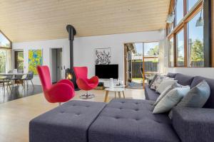 a living room with a gray couch and red chairs at 8565-Grenaa-Kystvej-58 in Grenå