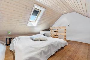 a bedroom with a white bed in a attic at 8565-Grenaa-Kystvej-58 in Grenå