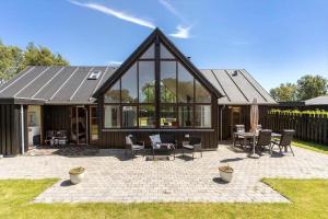 a home with a large glass building with a patio at 8565-Grenaa-Kystvej-58 in Grenå