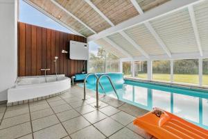 a bathroom with a tub and a swimming pool at 8927-Allingabro-Nordvangsvej-27 in Allingåbro