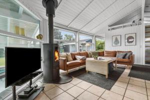 a living room with a tv and a fireplace at 8927-Allingabro-Nordvangsvej-27 in Allingåbro