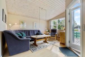 a living room with a blue couch and a table at 8960-Orsted-Ternevej-15 in Ørsted