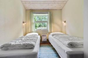 two beds in a room with a window at 8960-Orsted-Ternevej-15 in Ørsted