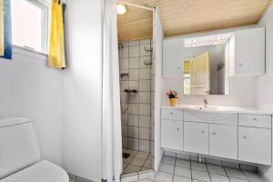 a bathroom with a white sink and a shower at 8960-Orsted-Ternevej-15 in Ørsted +18 photos