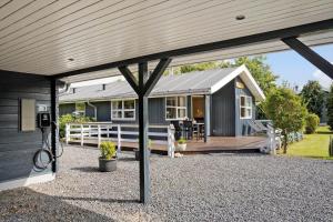 a house with a covered porch and a deck at 8960-Orsted-Ternevej-15 in Ørsted