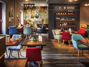 a restaurant with colorful chairs and tables and a bar at Mercure Wien Zentrum in Vienna